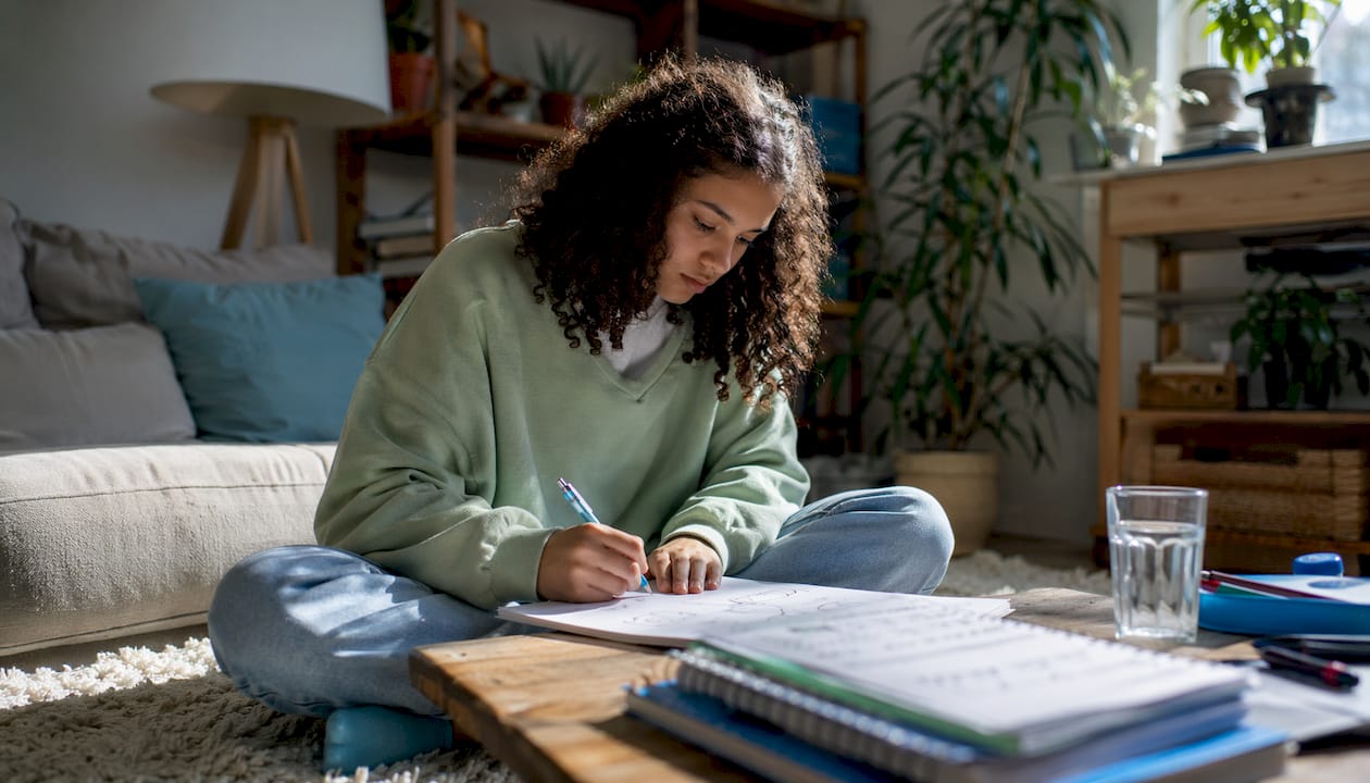 Student studying closed system diagrams at kitchen table