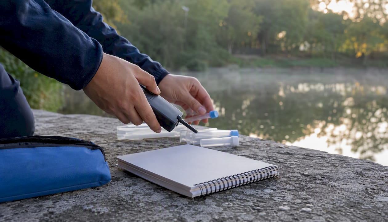 Hands setting up ESS fieldwork tools by river