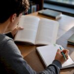 Student checking source attribution at library table