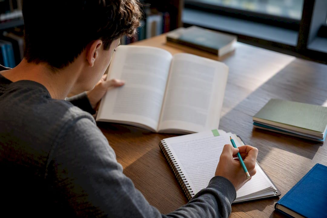 Student checking source attribution at library table