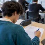 Student annotating an IB ESS exam response